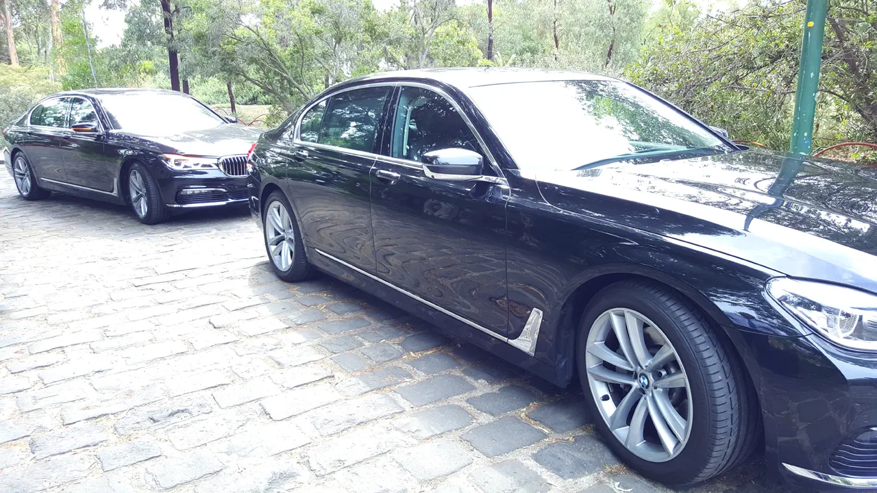 BMW's in a line on cobblestone